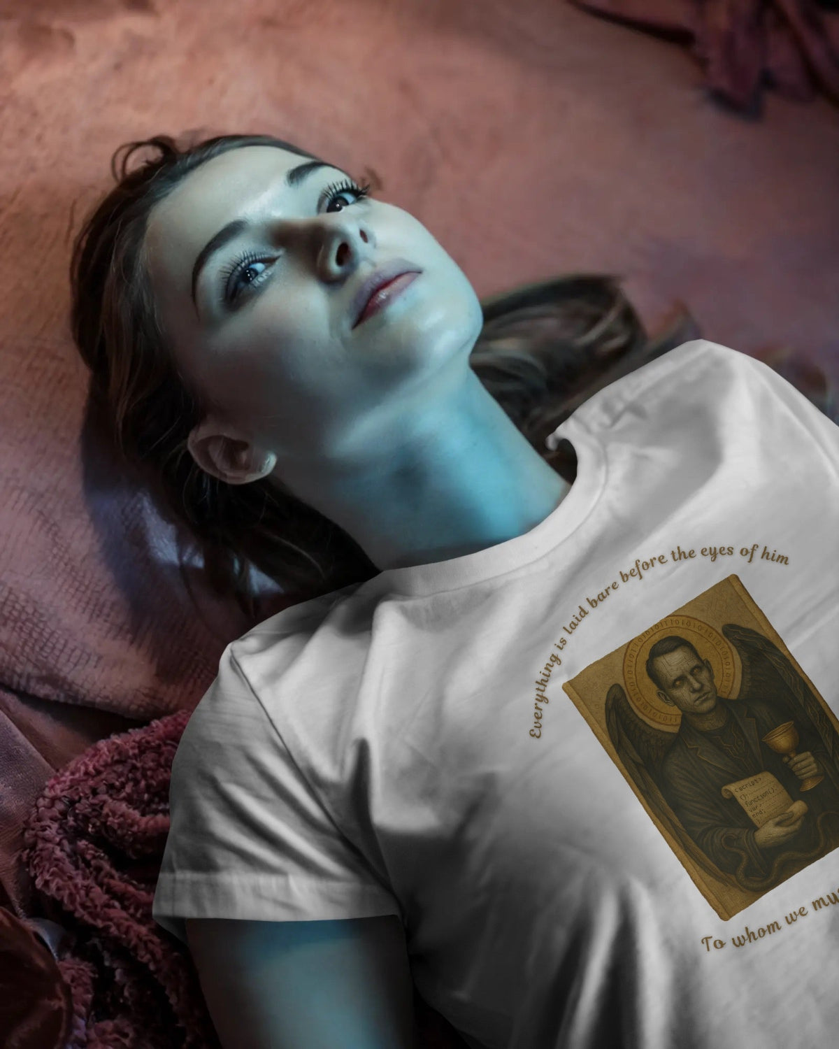 Person wearing a t-shirt with a printed design, lying on a textured surface.