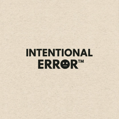 Text 'INTENTIONAL ERROR™' on a soft beige  t-shirt background